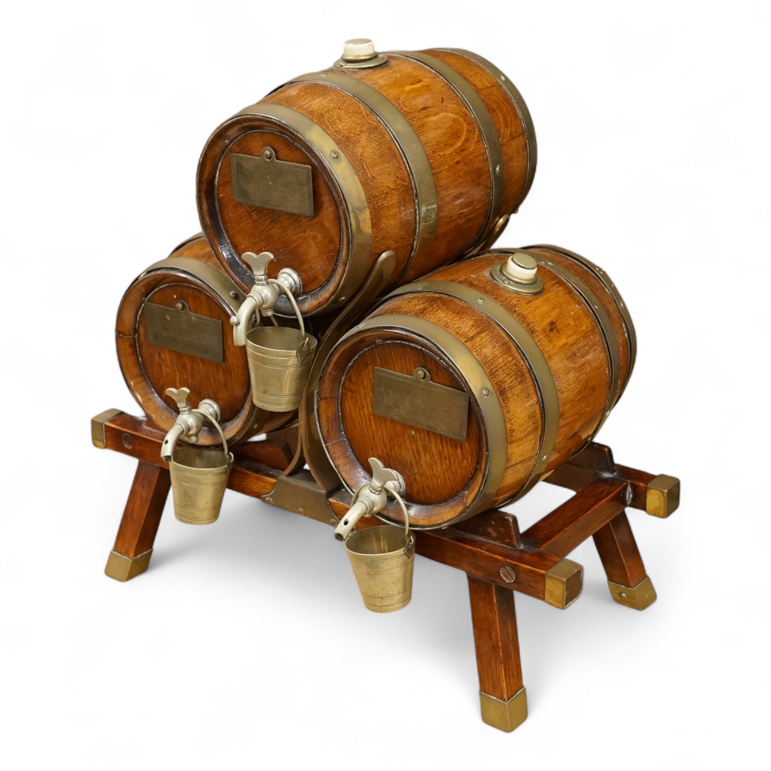 A set of three coopered oak and brass bound spirit barrels and stand, ivory mounted, early 20th century, 39cm wide. CITES Submission reference L87V7979